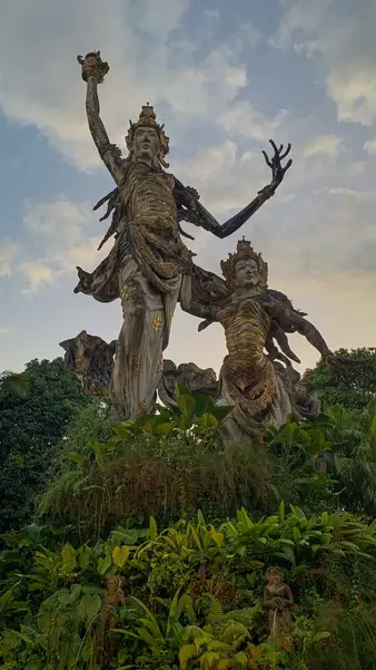 A stone statue rising over the treeline