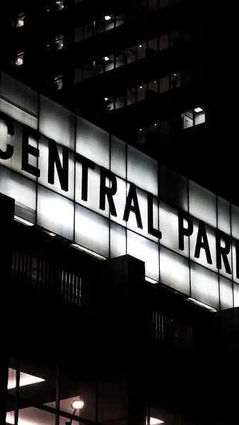 A Central Park sign along a lit facade