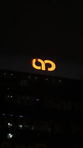 A single lit logo on an otherwise dark building