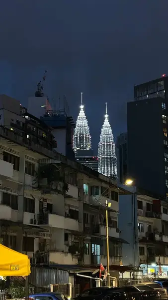 Petronas Towers over low rooftops at dusk