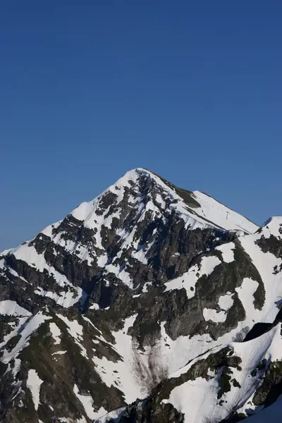 A snow-covered peak over the ridge